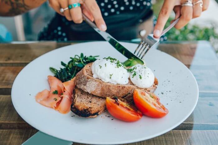 healthy keto meal serving suggestion with toast, tomatoes and spinach on a plate